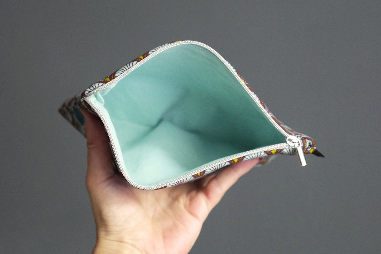 Sehr schlichter flacher Beutel aus himmelblauem Schuppenstoff mit silbernem Reißverschluss 20,5×14 cm