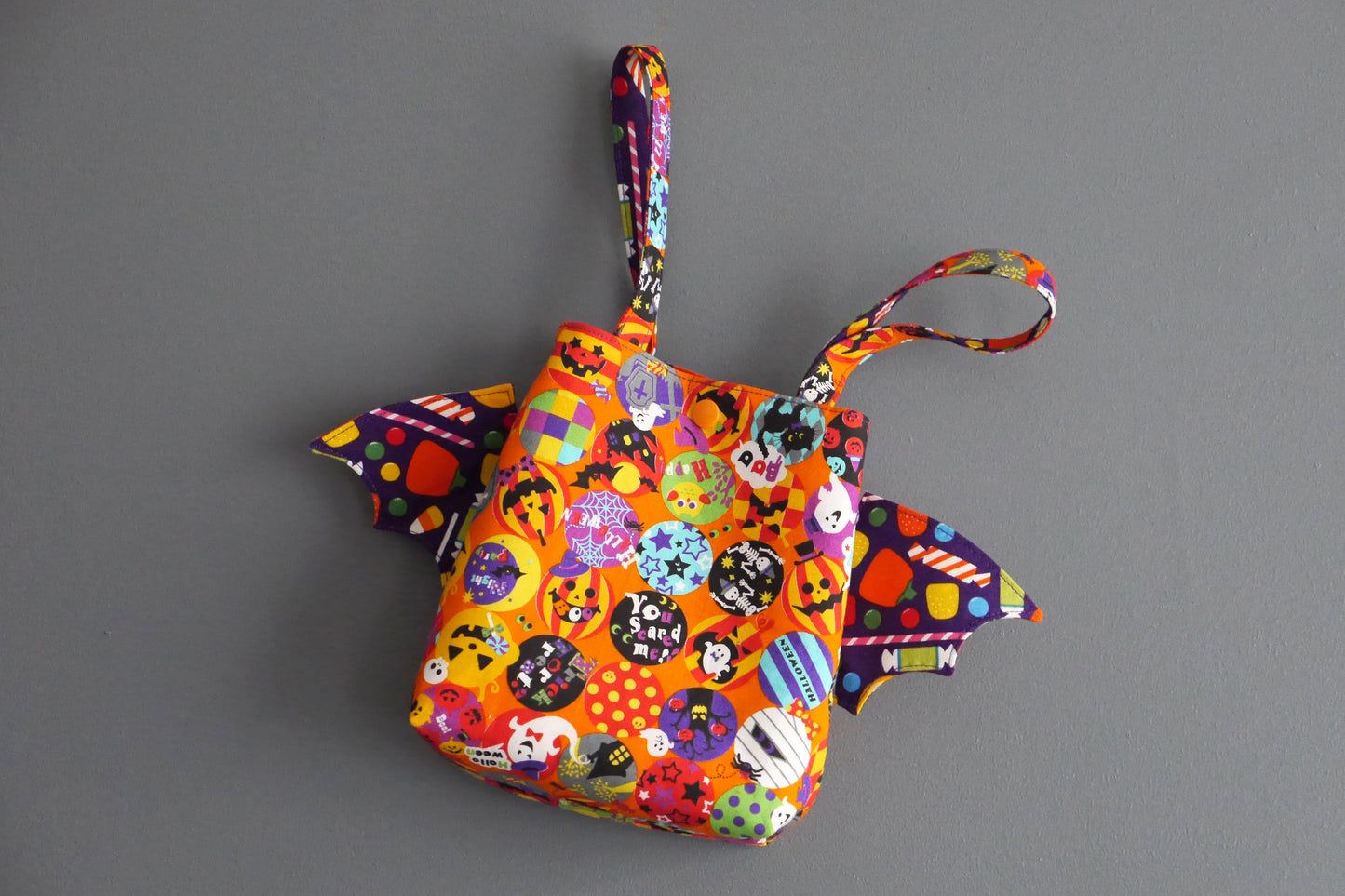 Sac à bonbons halloween panier enfant ailes de chauve-souris tissu orange coloré violet friandises monstres fantômes porté poignet