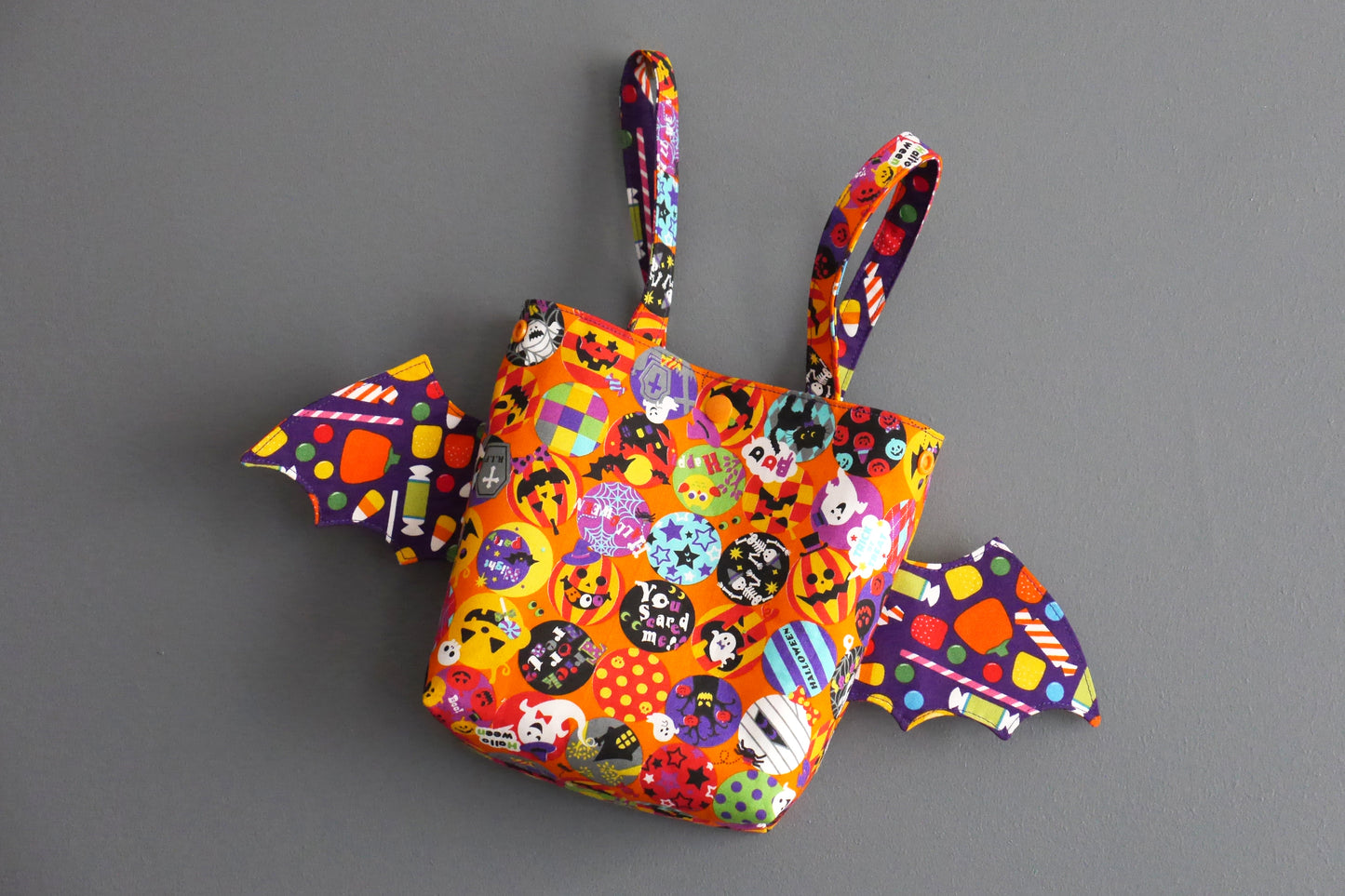 Sac à bonbons halloween panier enfant ailes de chauve-souris tissu orange coloré violet friandises monstres fantômes porté poignet