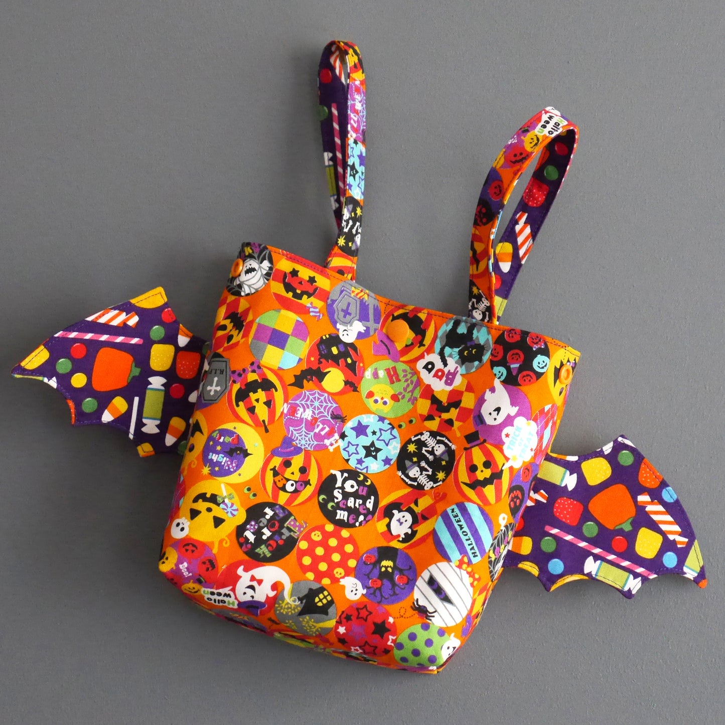 Sac à bonbons halloween panier enfant ailes de chauve-souris tissu orange coloré violet friandises monstres fantômes porté poignet
