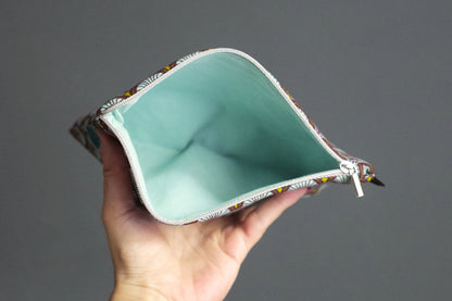 Sehr schlichter flacher Beutel aus himmelblauem Schuppenstoff mit silbernem Reißverschluss 20,5×14 cm